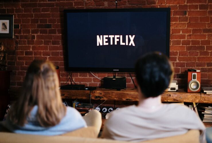 Persona viendo series en streaming en el sofá